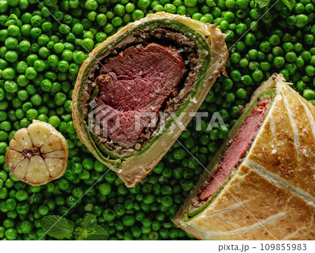 Homemade Christmas Beef Wellington as advent creation on green pees background. Food plating and aesthetic concept Homemade Christmas Beef Wellington as advent creation on green pees background. Food plating and aesthetic concept 109855983