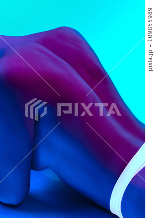 Cropped image of tender, attractive, naked female body part, relief back against blue background in neon light. Body aesthetics, beauty 109855989