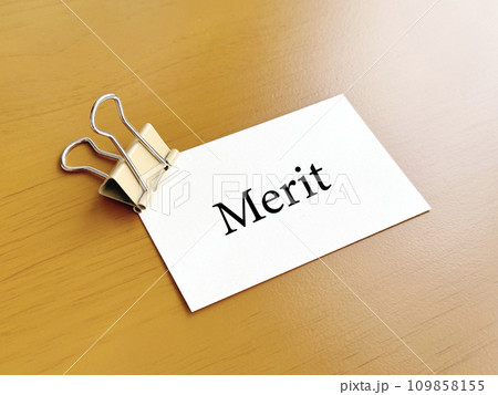 ベージュ色のダブルクリップで挟んだMerit文字入りメモ用紙_ななめ 109858155
