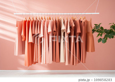 Warm knitted, autumn, winter clothes hanging on a rack, Peach Fuzz color of the year Warm knitted, autumn, winter clothes hanging on a rack, Peach Fuzz color of the year 109858283
