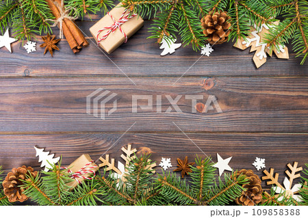 Christmas background with fir tree and gift box on wooden table. Top view with copy space for your design Christmas background with fir tree and gift box on wooden table. Top view with copy space for your design 109858388