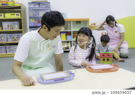 保育園でお絵描きをする女の子と男性保育士さん 撮影協力:有明教育芸術短期大学 保育園でお絵描きをする女の子と男性保育士さん 撮影協力:有明教育芸術短期大学 109859037