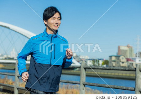 河川敷でランニングする男性 109859125