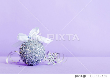 Christmas ball on colored background. decoration bauble with ribbon bow with copy space 109859320