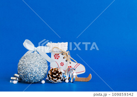 Christmas ball with skates on colored background. decoration bauble with ribbon bow with copy space 109859342