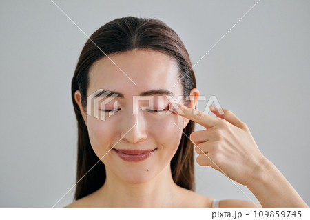 左目に指を当てる30代女性 109859745