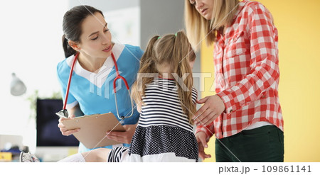 Little girl holding her neck at pediatrician doctor appointment Little girl holding her neck at pediatrician doctor appointment 109861141