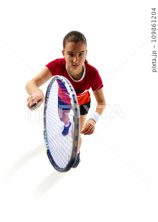 Energy and dedication. Top view. Skilled female badminton player in motion, training fervently against white studio background. 109861204
