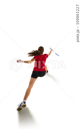 Dynamic portrait of fit and attractive young woman showcasing her badminton skills in action, epitomizing attack and defense against white background. Dynamic portrait of fit and attractive young woman showcasing her badminton skills in action, epitomizing attack and defense against white background. 109861227