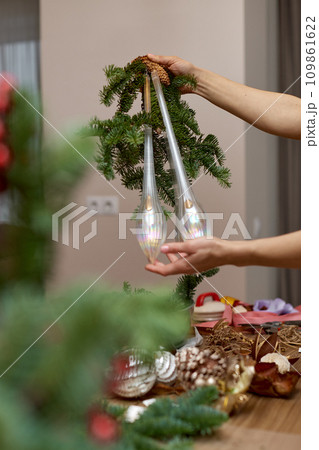 Woman making Christmas arrangement with fir branches. craft handmade decor. Woman making Christmas arrangement with fir branches. craft handmade decor. 109861622