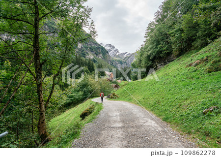View of rustic village and male backpacker in Alpstein mountain during summer at Appenzell, Switzerland 109862278