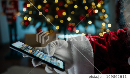 Santa Claus searching on his photo gallery  109862611