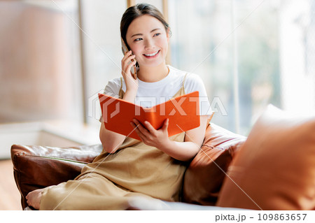 ソファに座って電話をする女性 109863657