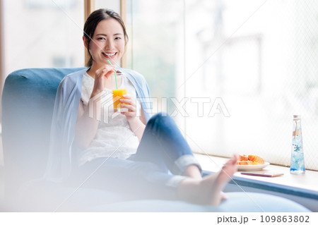 ソファに座って軽食を食べる女性 109863802