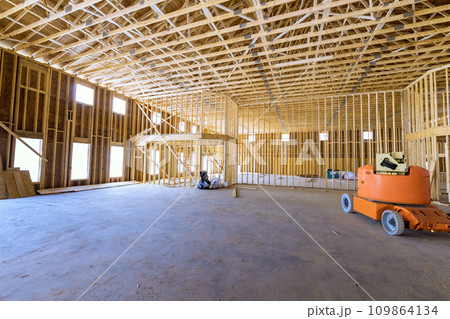 Wooden beams framework construction is under way for construction of new house 109864134