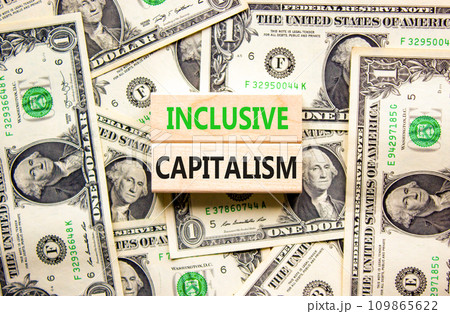 Inclusive capitalism symbol. Concept words Inclusive capitalism on beautiful wooden blocks. Dollar bills. Beautiful background from dollar bills. Business inclusive capitalism concept. Copy space. Inclusive capitalism symbol. Concept words Inclusive capitalism on beautiful wooden blocks. Dollar bills. Beautiful background from dollar bills. Business inclusive capitalism concept. Copy space. 109865622