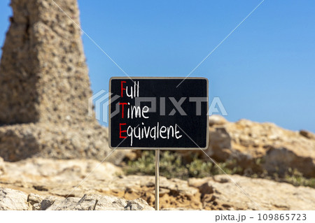 FTE Full time equivalent symbol. Concept words FTE Full time equivalent on beautiful black chalk blackboard. Beautiful stone beach background. Business and FTE Full time equivalent concept. Copy space FTE Full time equivalent symbol. Concept words FTE Full time equivalent on beautiful black chalk blackboard. Beautiful stone beach background. Business and FTE Full time equivalent concept. Copy space 109865723