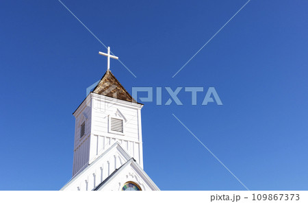 Wooden Church Steeple with Cross. White Old Church, Blue Sky On Background. Copy Space For Text. Christian Religious Holiday Easter or Radonitsa. Horizontal Plane 109867373