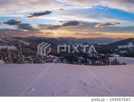Picturesque winter morning pre sunrise alps. View of famous Ukrainian Dragobrat ski resort from Svydovets mountain ridge. Picturesque winter morning pre sunrise alps. View of famous Ukrainian Dragobrat ski resort from Svydovets mountain ridge. 109867685