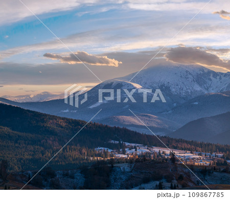 Late autumn mountain pre sunset scene with snow covered tops in far. Picturesque traveling, seasonal, nature and countryside beauty concept scene. Carpathians, Ukraine. Late autumn mountain pre sunset scene with snow covered tops in far. Picturesque traveling, seasonal, nature and countryside beauty concept scene. Carpathians, Ukraine. 109867785