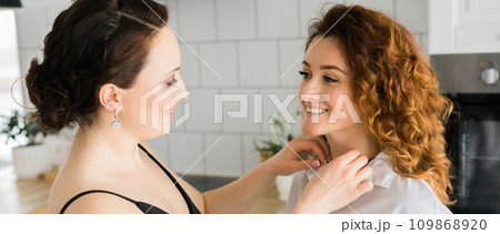 Banner Two cheerful woman enjoying shopping together jewellery boutique. Sister giving present jewelry pendant 109868920
