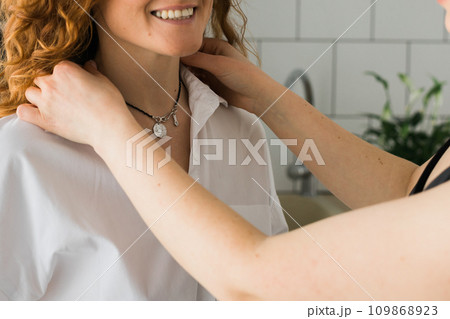 Close-up Two cheerful woman enjoying shopping together jewellery boutique. Sister giving present jewelry pendant Close-up Two cheerful woman enjoying shopping together jewellery boutique. Sister giving present jewelry pendant 109868923