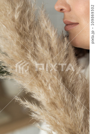 Close-up portrait of a beautiful woman looking out of Cortaderia pampas grass Close-up portrait of a beautiful woman looking out of Cortaderia pampas grass 109869302
