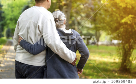 An elderly couple, man and woman walk in the autumn park. An elderly couple, man and woman walk in the autumn park. 109869488