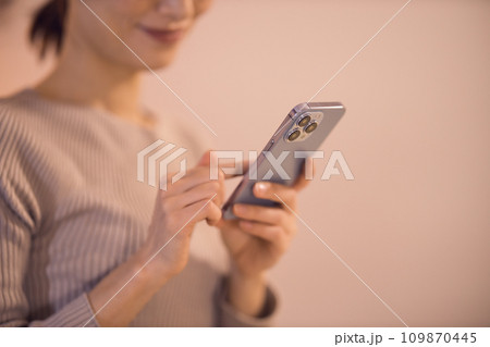 リビングでスマホを見る女性　ナイトルーティーン 109870445
