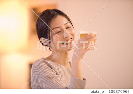 ビールを飲みながら夕食をとるビジネスウーマンのナイトルーティーン 109870962