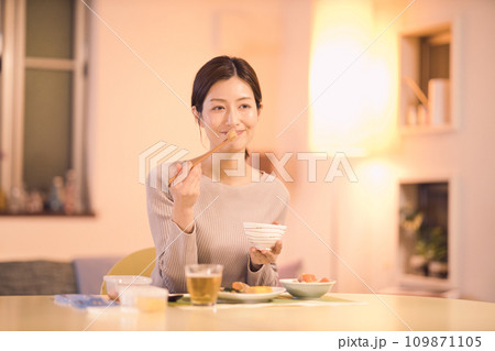 作り置きのお料理で夕食をとるビジネスウーマンのナイトルーティーン 109871105