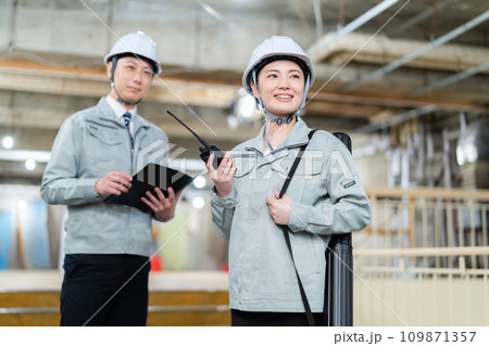 工事現場で打ち合わせをする男女のエンジニア 工事現場で打ち合わせをする男女のエンジニア 109871357