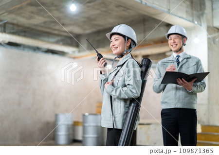 工事現場で打ち合わせをする男女のエンジニア 工事現場で打ち合わせをする男女のエンジニア 109871365