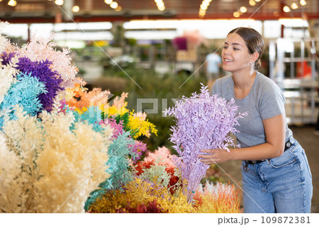 Female shopper chooses Ruscus Italie flowers for a bouquet at flower market Female shopper chooses Ruscus Italie flowers for a bouquet at flower market 109872381