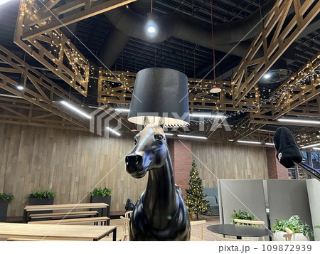 Interior of a modern cafe with a horse head in the foreground. Interior of a modern cafe with a horse head in the foreground. 109872939