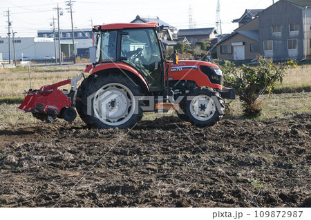畑で作業するトラクター 109872987