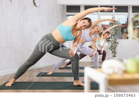 Young woman practicing pilates exercises in yoga studio 109873463