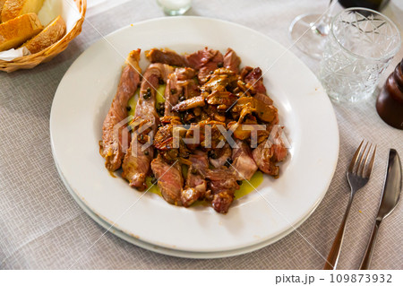Sliced tagliata steak with sauteed white mushrooms on plate Sliced tagliata steak with sauteed white mushrooms on plate 109873932