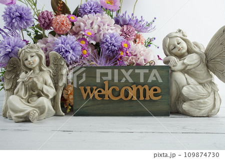 Welcome sign with flowers bouquet and angel statues home decorations Welcome sign with flowers bouquet and angel statues home decorations 109874730