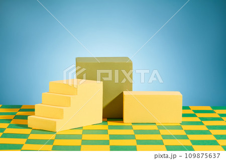 A staircase in yellow color arranged with other podiums on green and yellow checked surface. Platforms cosmetic product presentation A staircase in yellow color arranged with other podiums on green and yellow checked surface. Platforms cosmetic product presentation 109875637