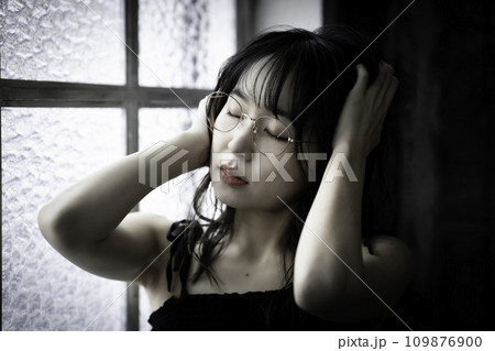 アンニュイな雰囲気の眼鏡の若い女性 109876900