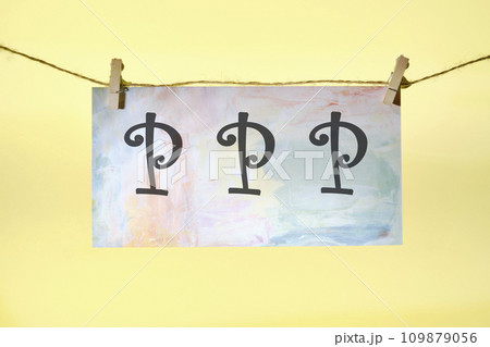 Paycheck Protection Program PPP lettering on colored paper hanging in front of a yellow background with a rope and clothespins Paycheck Protection Program PPP lettering on colored paper hanging in front of a yellow background with a rope and clothespins 109879056