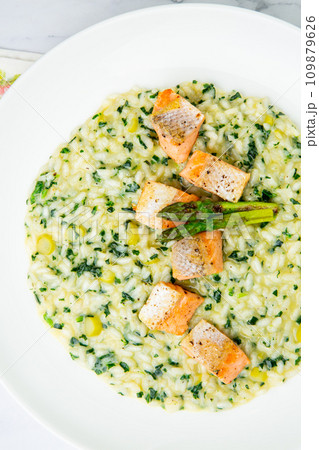 rice porridge with artichoke, red fish and herbs in a white plate, top view rice porridge with artichoke, red fish and herbs in a white plate, top view 109879626