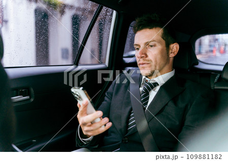 タクシーの中でスマホを見る欧米人ビジネスマン 109881182
