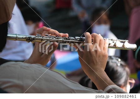 Close-up of the hands of a musician playing the flute. Hands of man playing a flute. Close-up of the hands of a musician playing the flute. Hands of man playing a flute. 109882461