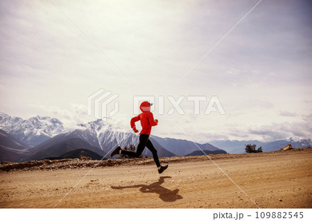 Woman trail runner cross country running at high altitude mountains Woman trail runner cross country running at high altitude mountains 109882545