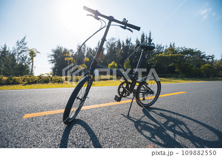 A folding bike on sunrise seaside road A folding bike on sunrise seaside road 109882550