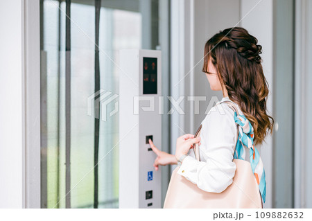 エレベーターのボタンを押すビジネスウーマン 109882632