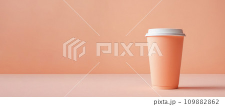 coffee cup on table. Monochrome peach fuzz background. side view, banner. Modern trendy tone. paper cup in trendy color of year 2024 Peach Fuzz 109882862