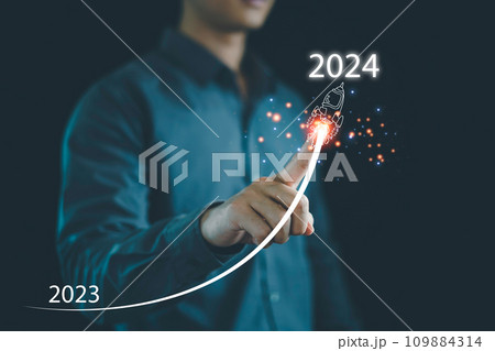 Businessman hand draws line for increasing arrow from 2023 to 2024, New goals, Plans and visions for next year 2024, Preparation merry Christmas and happy new year concept. new business. 109884314
